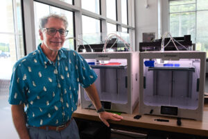 person standing next to 3D printer