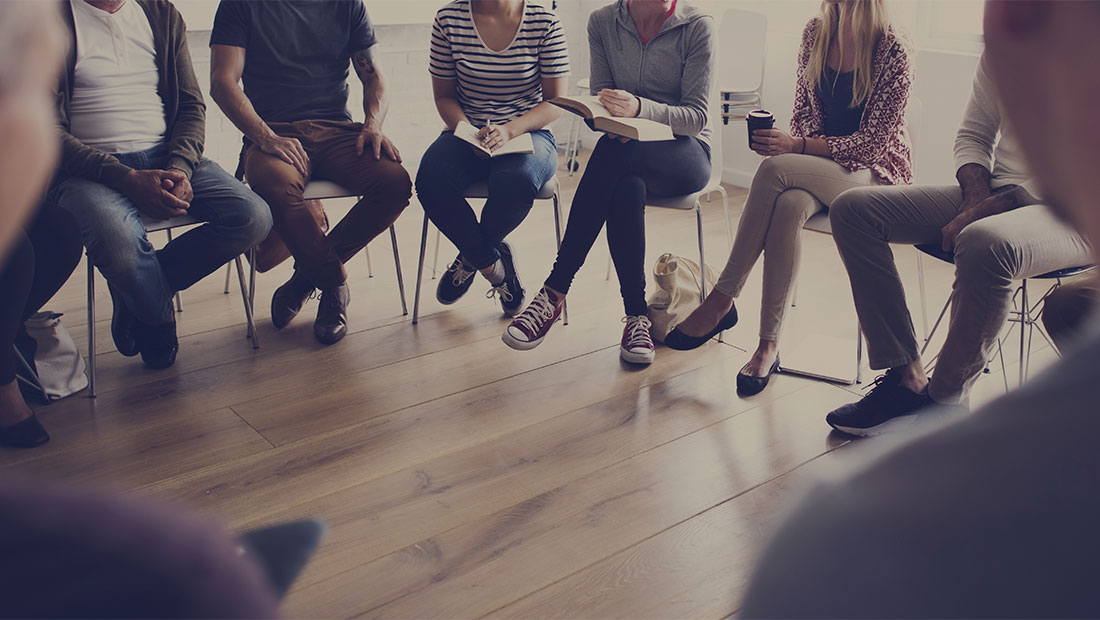 Group of people sitting in a circle in chairs