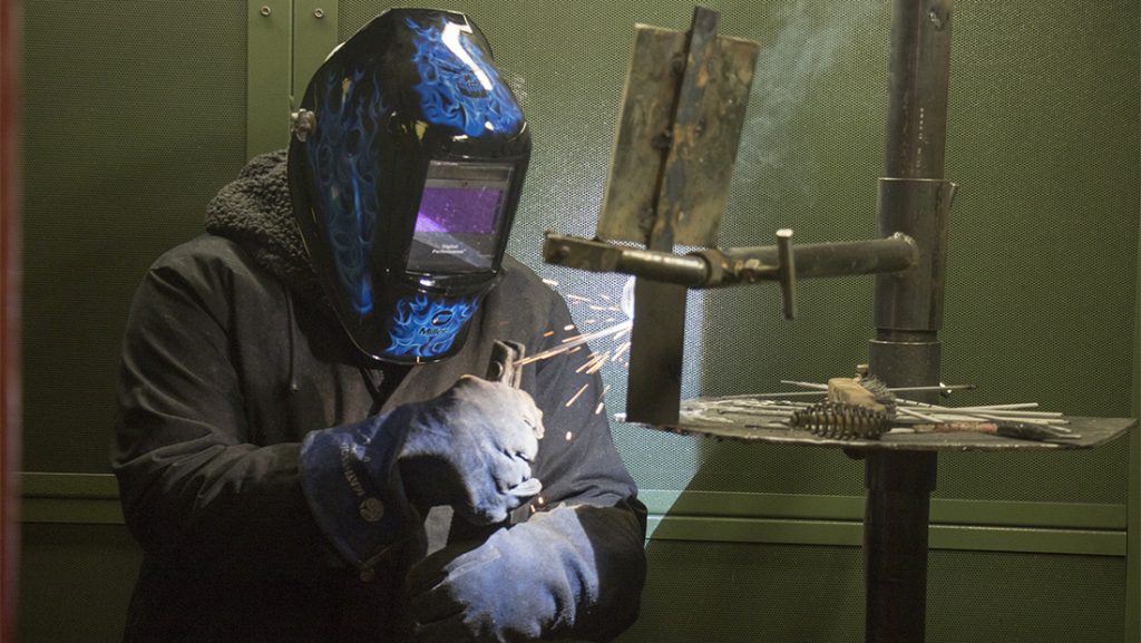 Person welding a piece of steel
