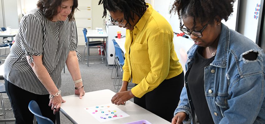 instructor working with two education students